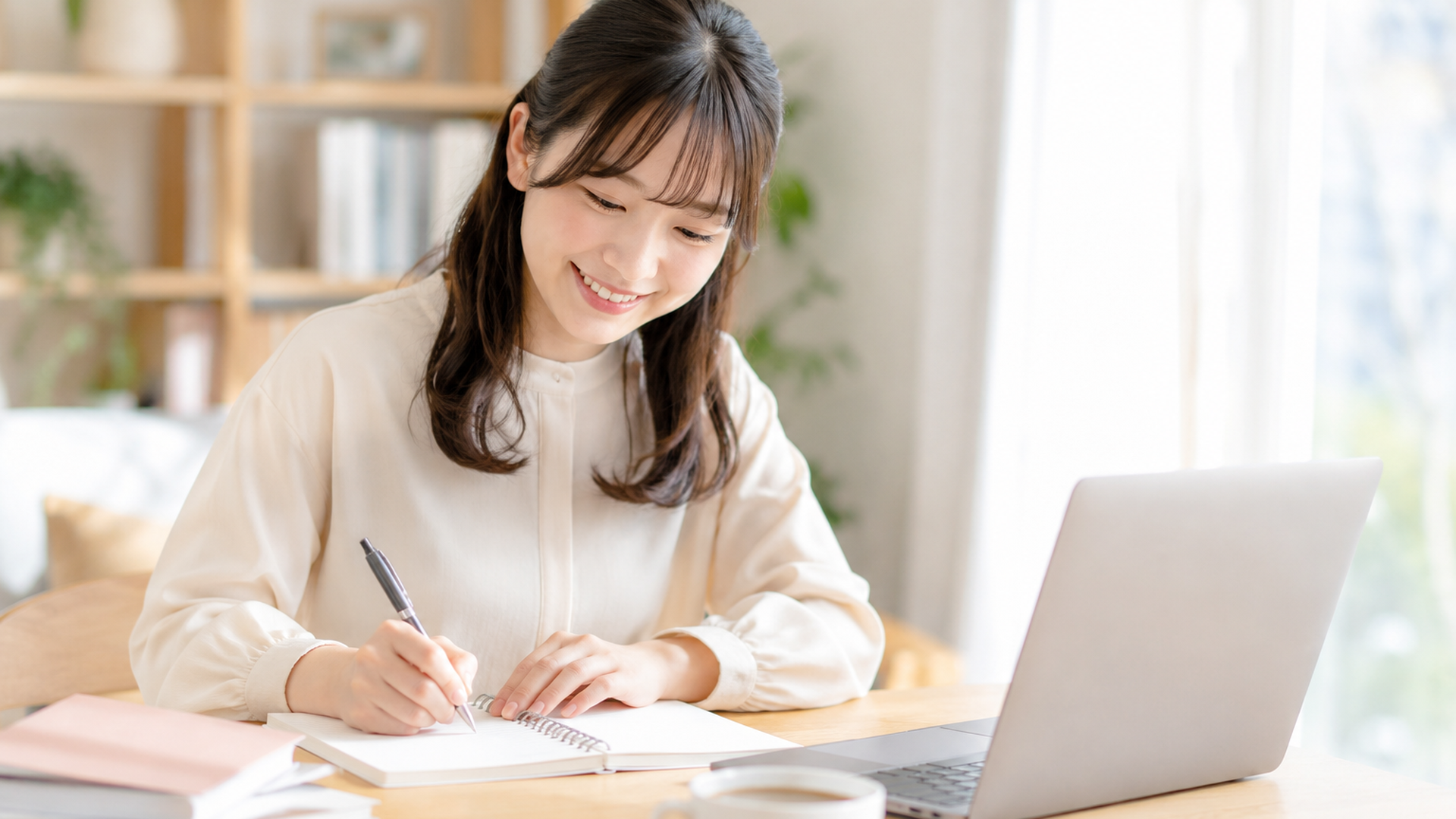 ノートとペンでステップを書き出しながら計画を立てる20代日本人女性